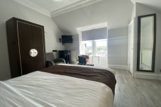 A spacious bedroom with a king-size bed in No6 West Coates, Haymarket, Edinburgh.