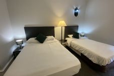 A triple bedroom with soft lighting, neatly arranged bedding, and ample space at No.6 West Coates Hotel in Edinburgh.