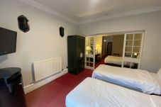 Bright bedroom at No.6 West Coates, featuring a queen and single beds