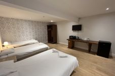 View of the spacious bedroom layout at Park View House Hotel with double and single beds.